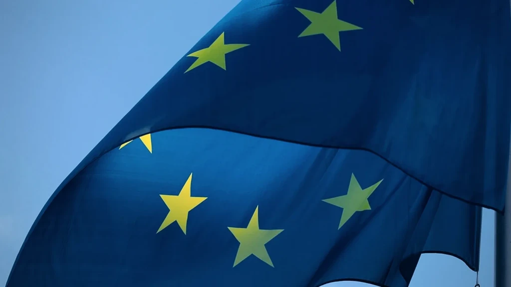 Drapeau européen claquant au vent, étoiles dorées sur fond bleu