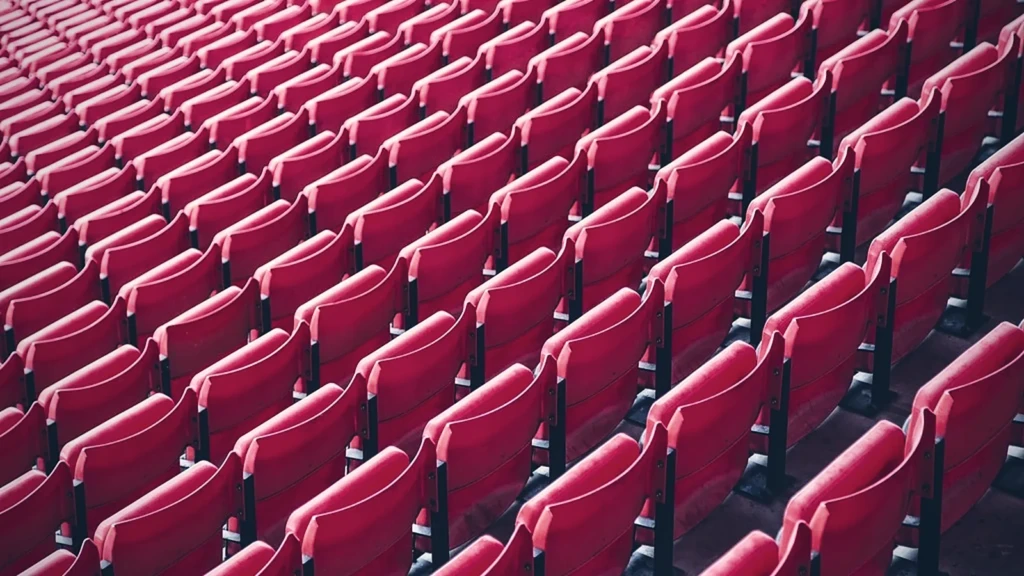 Rangées serrées de fauteuils rouges dans une salle vide