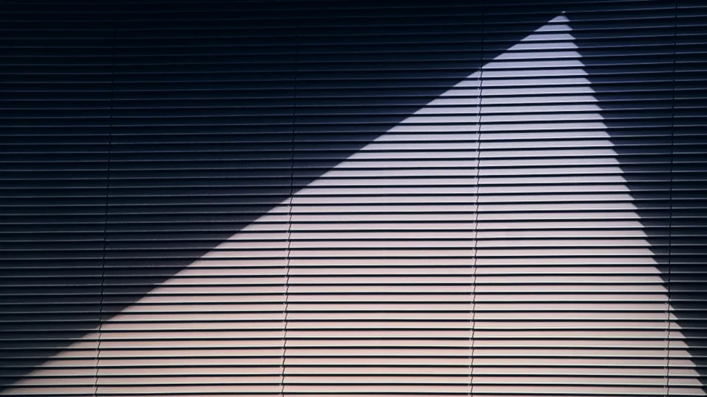 Ombre portée en diagonale sur une façade à claire-voie