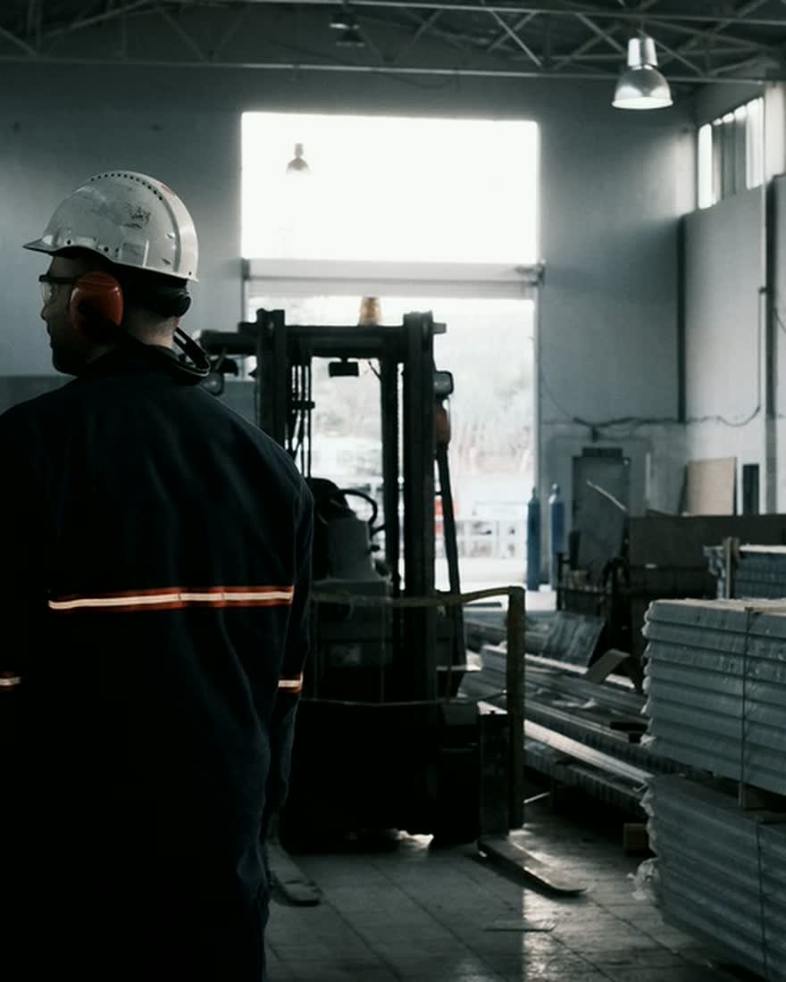 Technicien en équipement de protection supervisant une installation de production